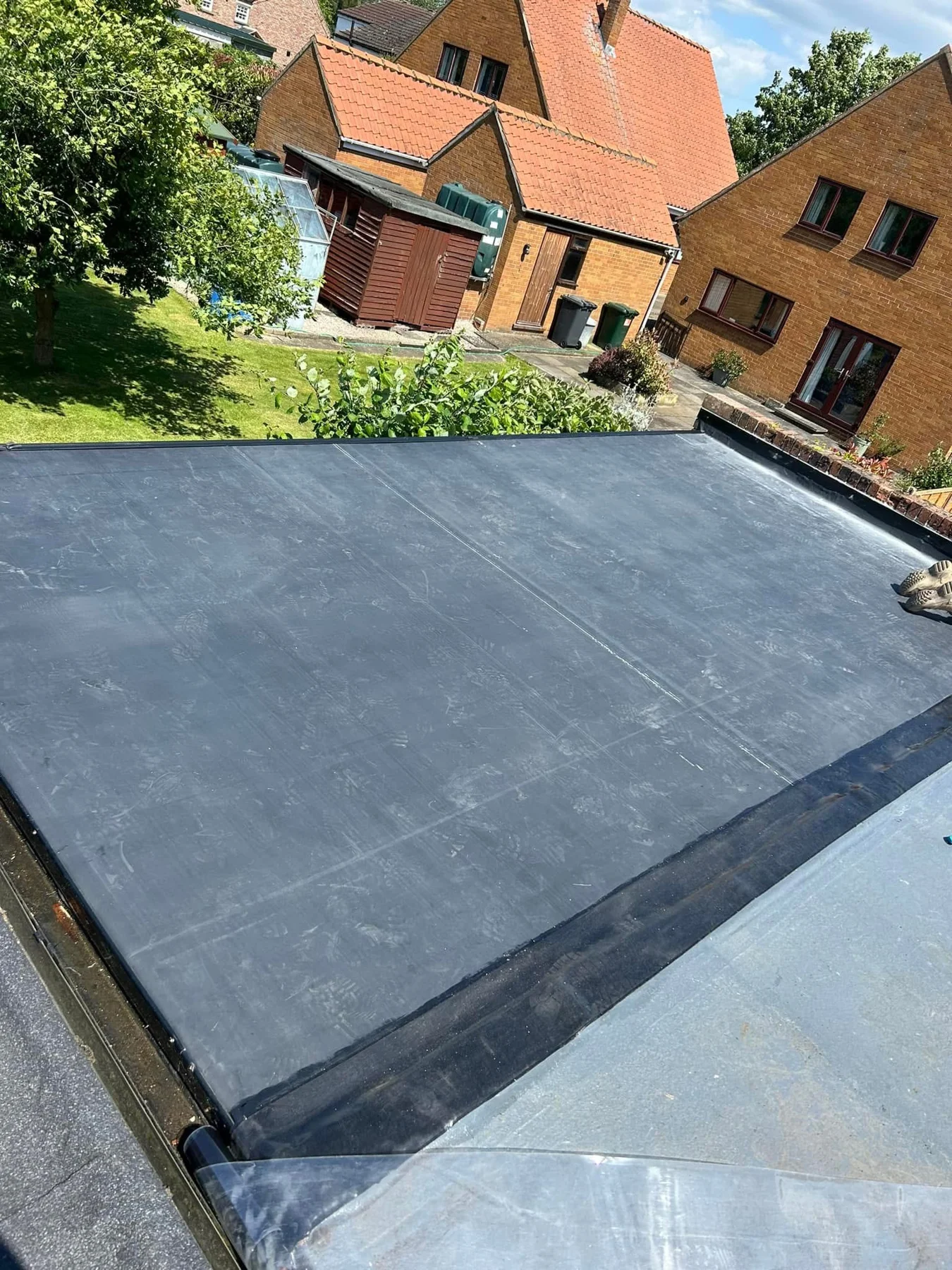 Dark flat roof surface and perimeter edge detailing