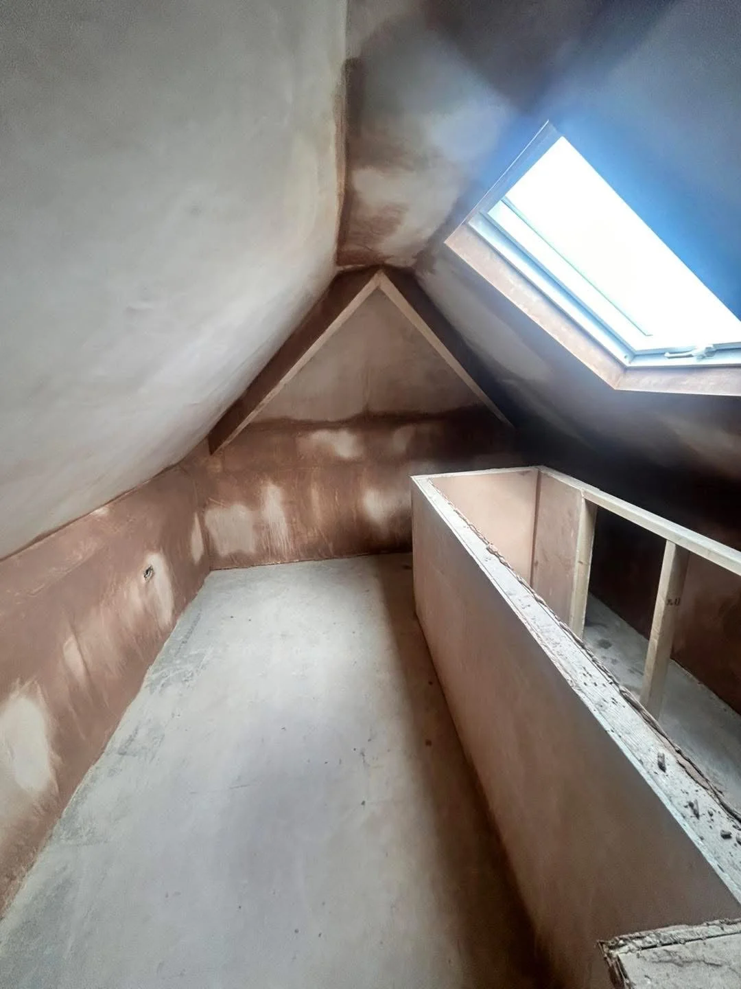 Plastered loft space with a roof window