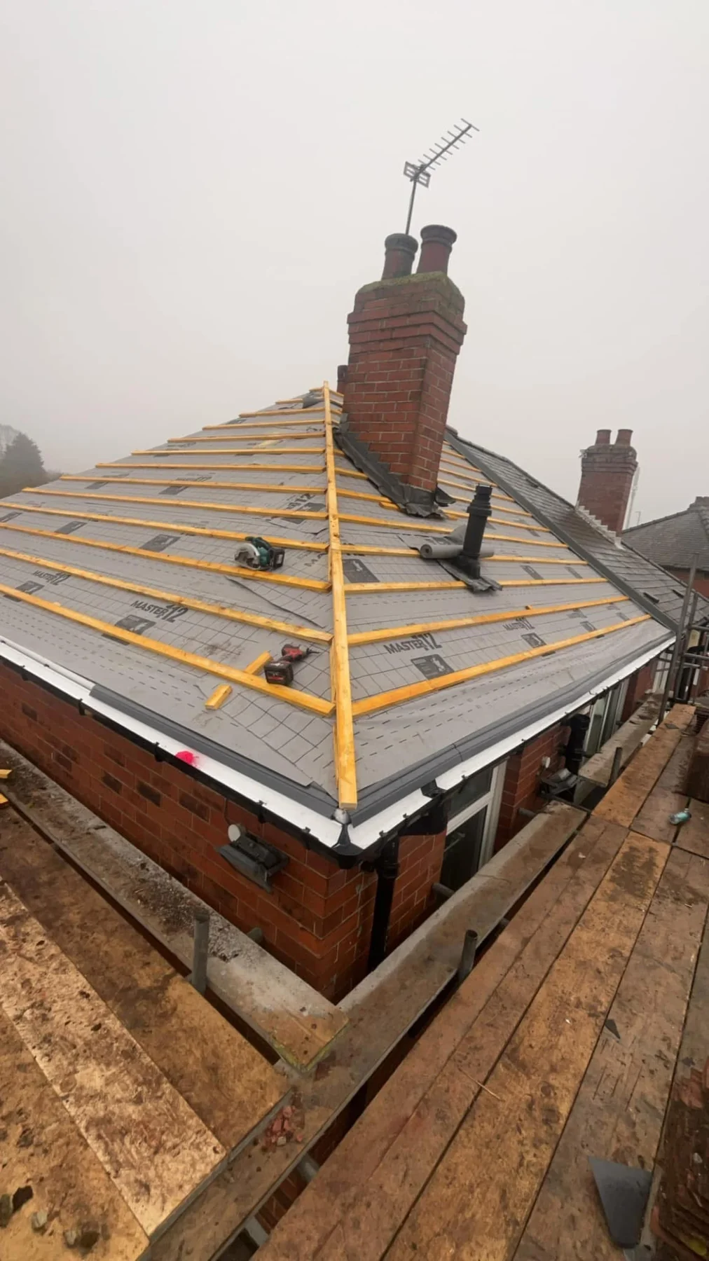 Roofing membrane and battens around a brick chimney