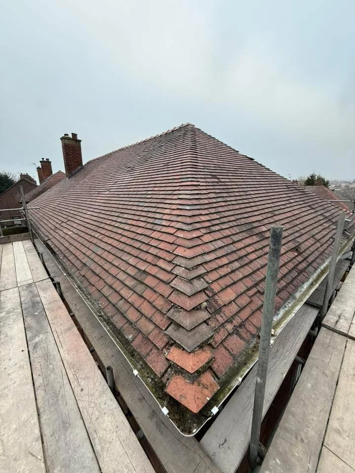 Existing red tiled hip roof before replacement